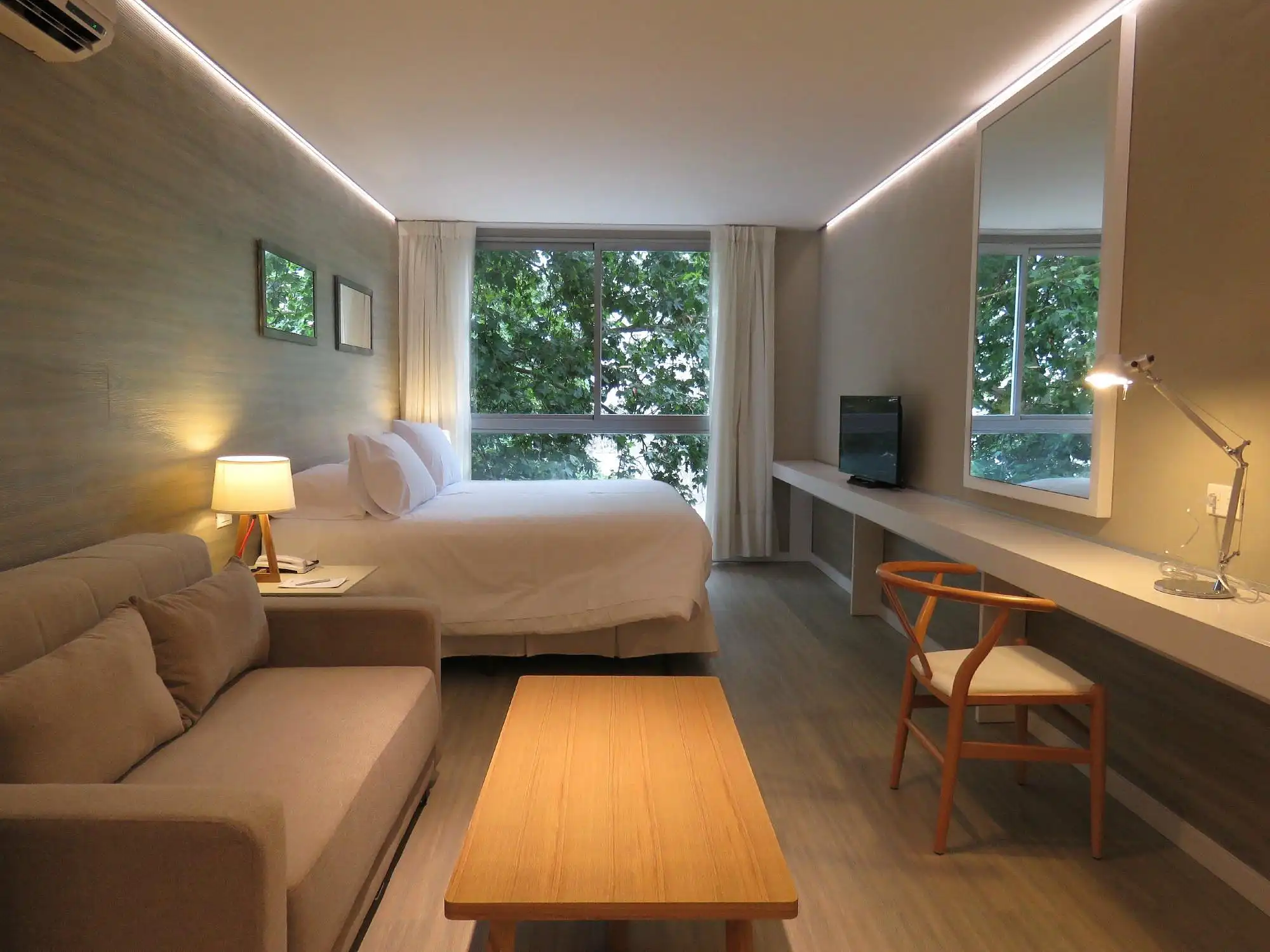 dormitorio_cama_matrimonial_escritorio_tv_living_ventana_smart_hotel_montevideo.webp